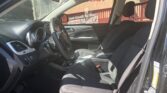 Front interior of a black SUV with the driver’s seat and passenger seat visible, steering wheel and center console in view; door open on the right side.
