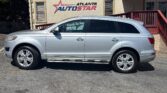 Silver SUV parked in front of a beige Atlanta Auto Star dealership building with a large blue phone number on the wall.