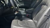 Black leather front seats with steering wheel and center console visible in the car interior.