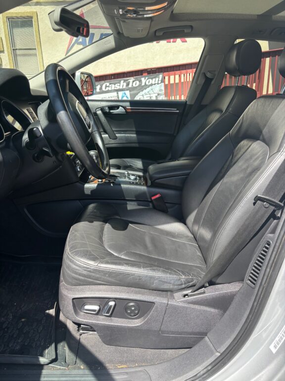 Black leather front seats with steering wheel and center console visible in the car interior.