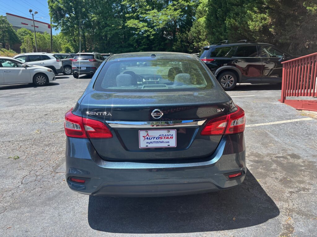 Rear view of a dark gray Nissan Sentra SV parked in a lot; dealer plate reads Atlanta Autostar/Atlanta Autostar frame is visible.