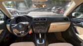 Interior of a car cockpit with beige seats, black dashboard, and steering wheel viewed from the front passenger seat.