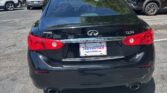 Black Infiniti Q50 seen from the rear in a parking lot, with a dealership plate frame reading AUTOSTAR Atlanta Autos for sale.