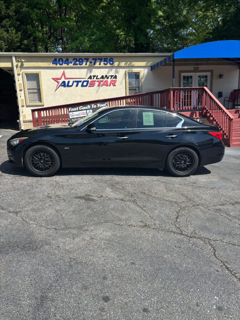 Black sedan parked in front of Atlanta AutoStar dealership with the storefront and blue phone number sign visible