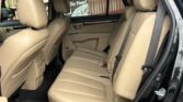Beige leather back seats in a car with the rear passenger door open, front seats visible.
