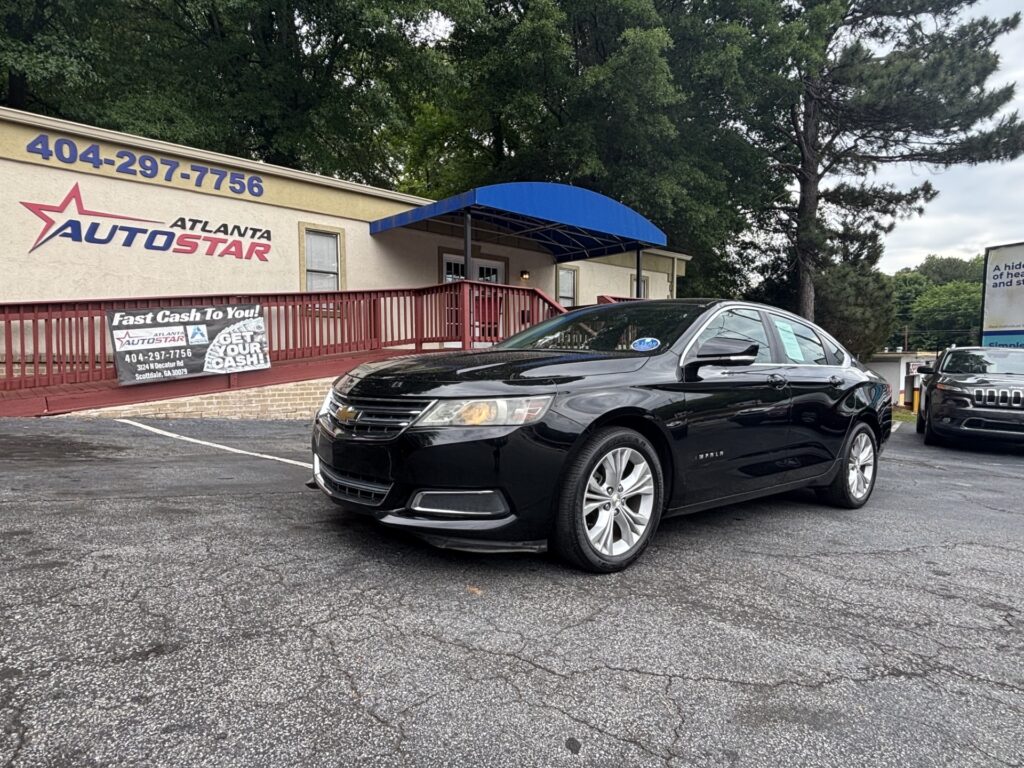 Black Chevrolet sedan parked in front of Atlanta AutoStar dealership with a blue awning and banners on the railing.