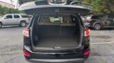 Back of a black SUV with the trunk open, showing an empty beige cargo area in a parking lot.