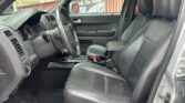 Front interior of a dark gray pickup truck with black leather seats, steering wheel, and center console visible