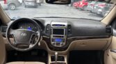 View from the driver’s seat inside a beige SUV, showing steering wheel, dashboard, and center console with gear shifter.