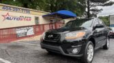 Black SUV parked in front of the Atlanta AutoStar dealership under a blue canopy.