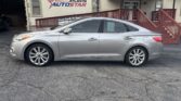 Silver four-door sedan parked in front of Atlanta Auto Star dealership with a blue canopy.
