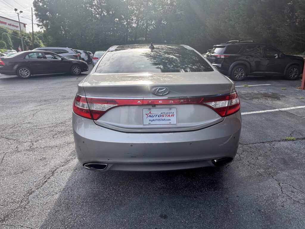 Rear view of a silver Hyundai Azera parked in a lot with other cars and an Atlanta AutoStar plate frame visible on the trunk rear light strip