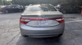Rear view of a silver Hyundai Azera parked in a lot with other cars and an Atlanta AutoStar plate frame visible on the trunk rear light strip
