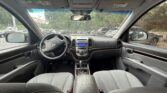 Interior of a car viewed from the back seat, showing steering wheel, center console, and front seats with gray upholstery