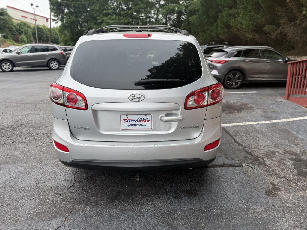 Rear view of a silver Hyundai SUV in a parking lot, dealership plate reading ATLANTA AUTO STAR on the back window area.
