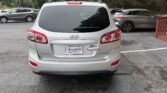 Rear view of a silver Hyundai SUV in a parking lot, dealership plate reading ATLANTA AUTO STAR on the back window area.