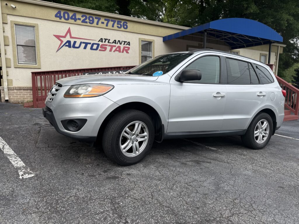 Silver SUV parked in front of Atlanta Auto Star dealership with a blue awning.