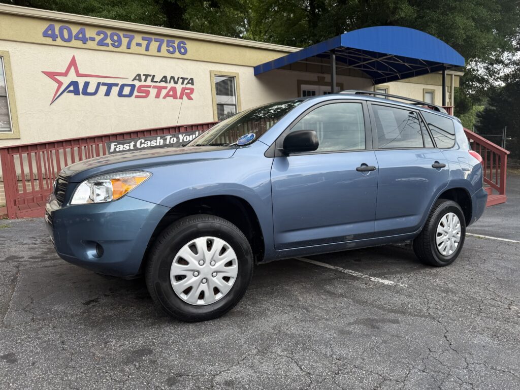 Blue SUV parked in front of Atlanta AutoStar dealership with a blue awning and sign on the building