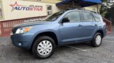 Blue SUV parked in front of Atlanta AutoStar dealership with a blue awning and sign on the building