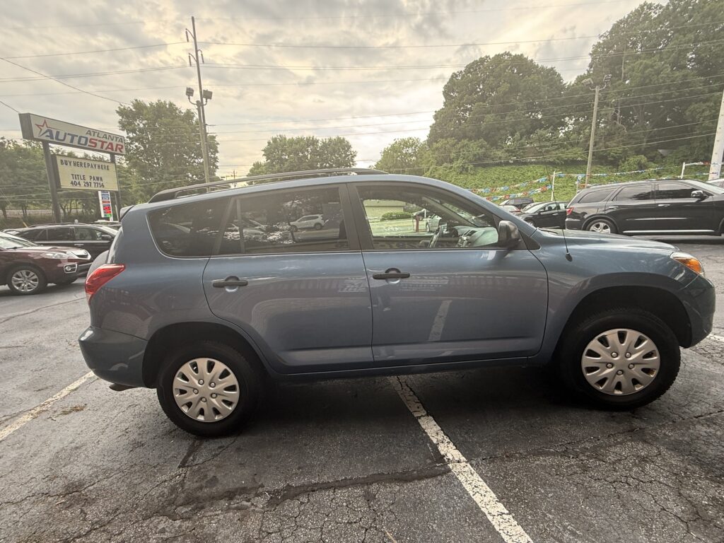 Blue SUV parked in a used-car lot with other vehicles and a sign in the background reading Auto Star Atlanta.