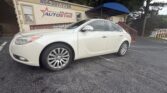 White sedan parked in a lot in front of a beige building with a blue curved awning and Atlanta AutoStar sign visible