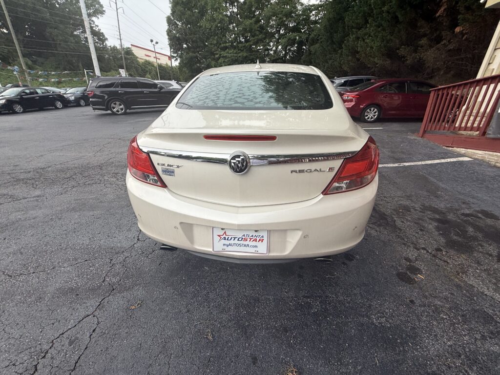 Rear of a white Buick Regal LT in a car dealership lot, with Atlanta Autostar plate.