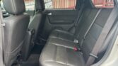 Back seat of a car with black leather upholstery and three seating positions including visible seat belts.