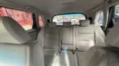 Back seat of a beige leather car interior with three headrests and visible seat belts, seen from the front passenger area.