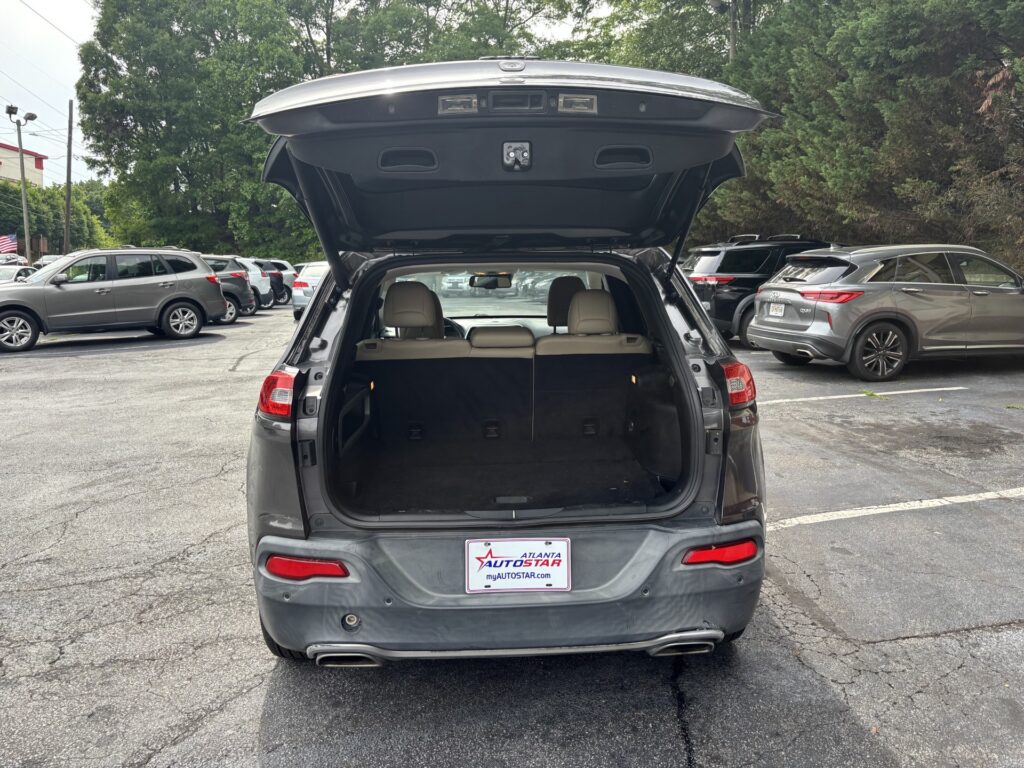 Rear of a gray SUV with its hatch open, showing the cargo area in a parking lot