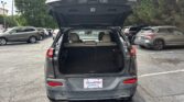 Rear of a gray SUV with its hatch open, showing the cargo area in a parking lot