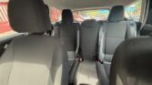 Interior of a gray, three-row car showing front seats and two rear rows with headrests and visible seat belts.