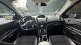 Interior of a car cabin viewed from the back seat, showing steering wheel, center console, gear shifter, and front dashboard.