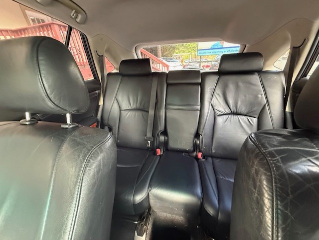 Back seat of a car with black leather upholstery and three seating positions with headrests and belts visible?