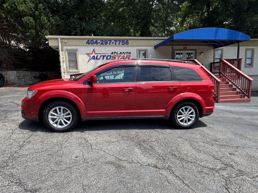 Red SUV parked in front of a building with 'Atlanta AutoStar' sign and a blue awning overhead