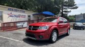 Red Dodge SUV parked in front of the Atlanta Auto Star dealership, under a blue awning with the sign above.