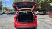 Red SUV with its hatchback open, showing an empty cargo area in a parking lot.